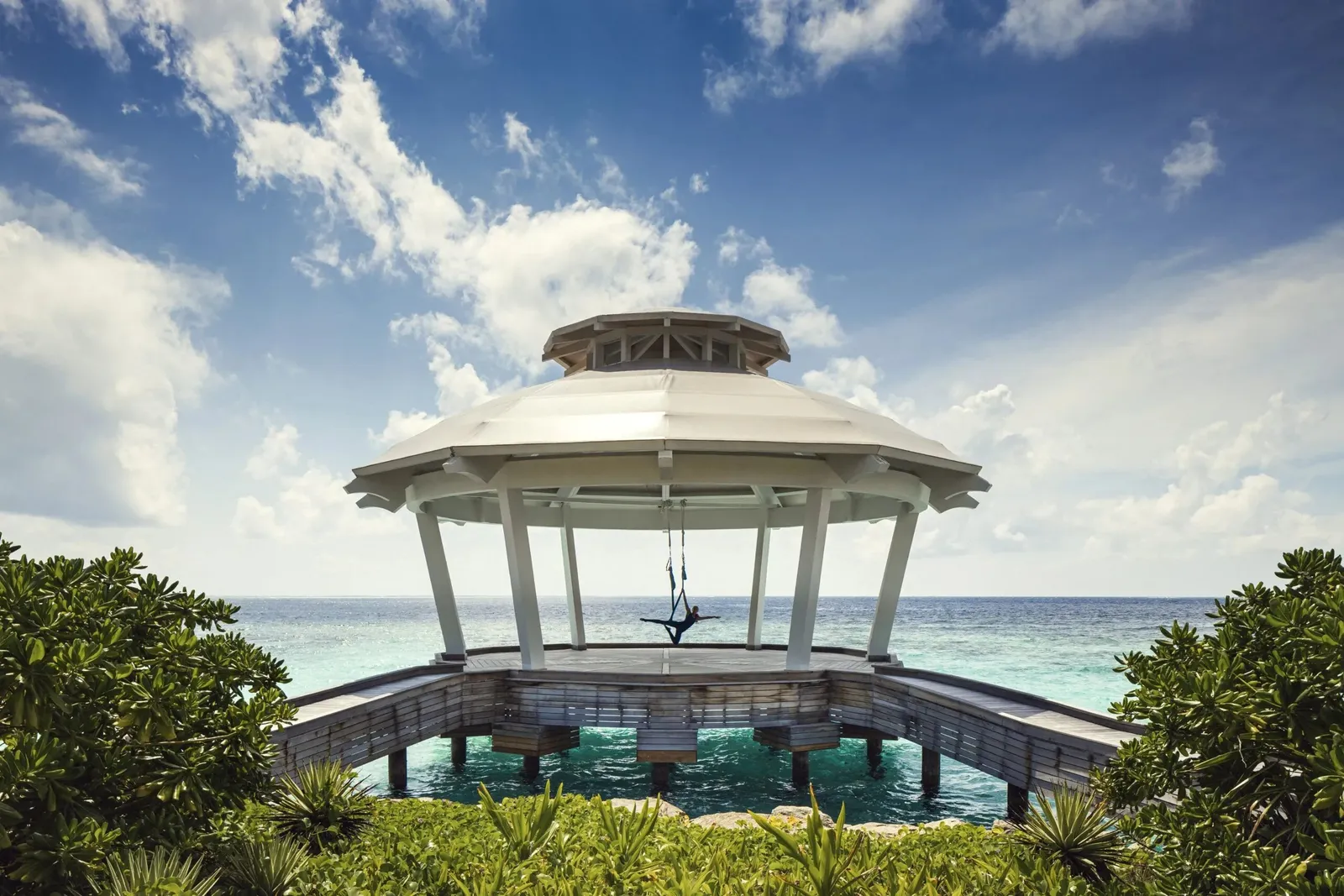 The yoga pavilion over the water, white, at the end of its jetty