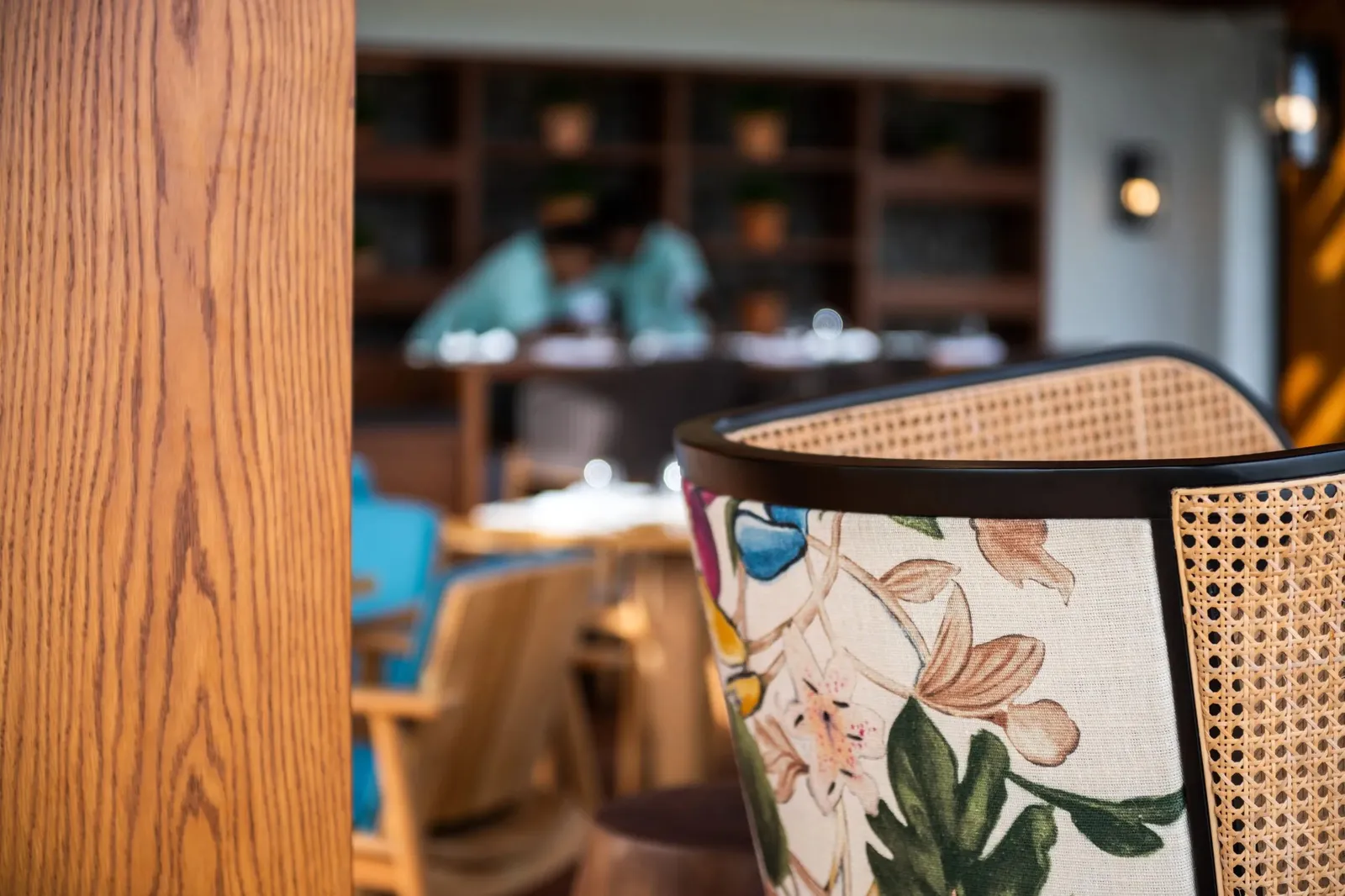 A table laid in one of the restaurants, rattan chairs and floral fabric