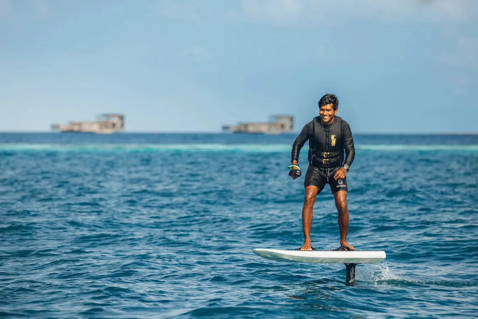 A man standing on an e-foil above the blue sea
