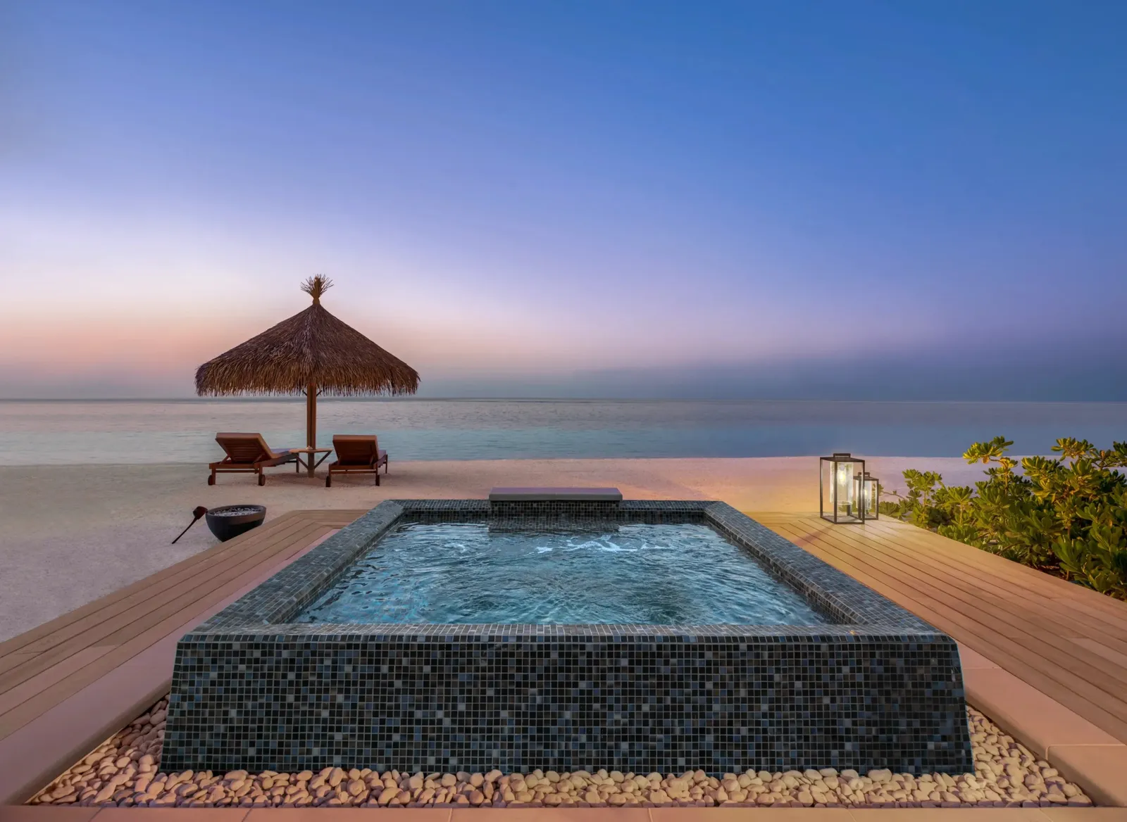 The hot tub on a Grand Beach Villa’s deck, the sea at sunset