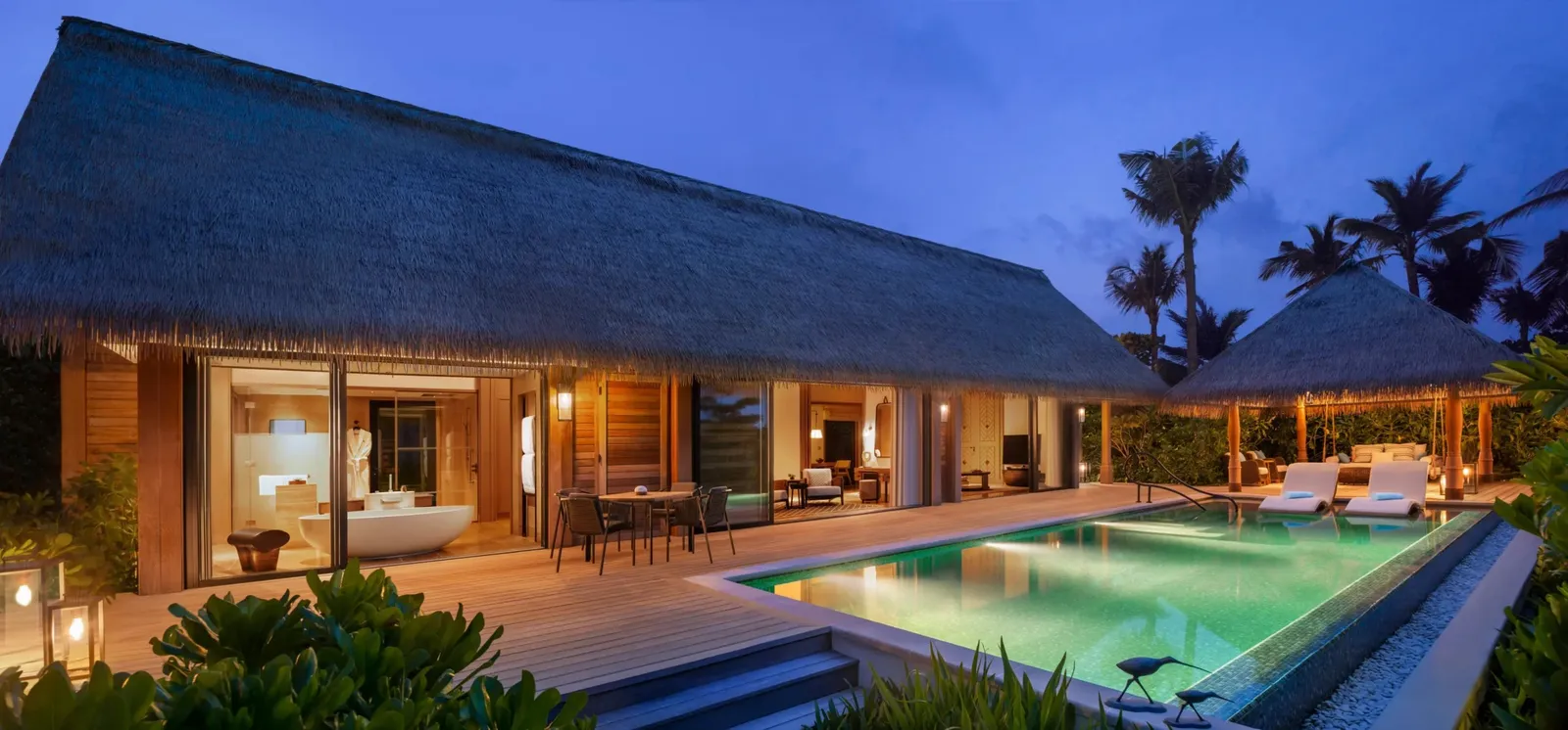 King Grand Beach Villa at dusk, the lit pool before the living room