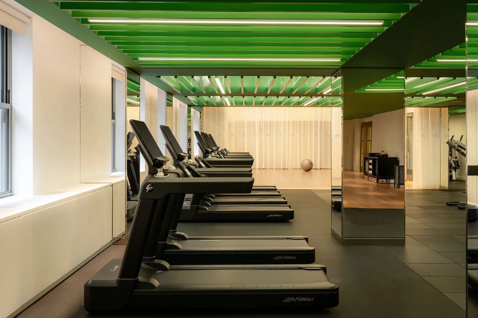 The gym with its green ceiling and treadmills