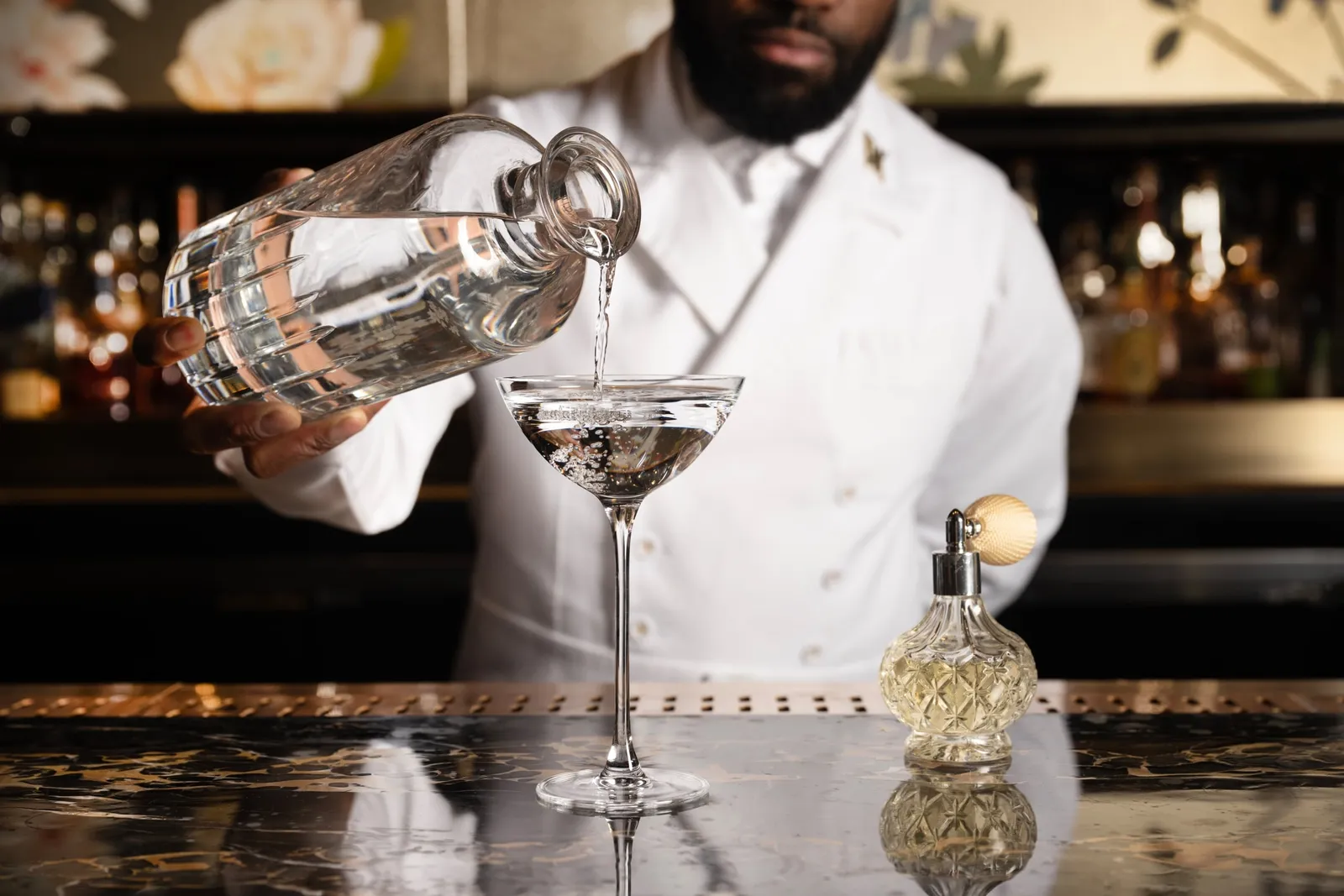 A bartender pouring a martini at the Peacock Alley bar