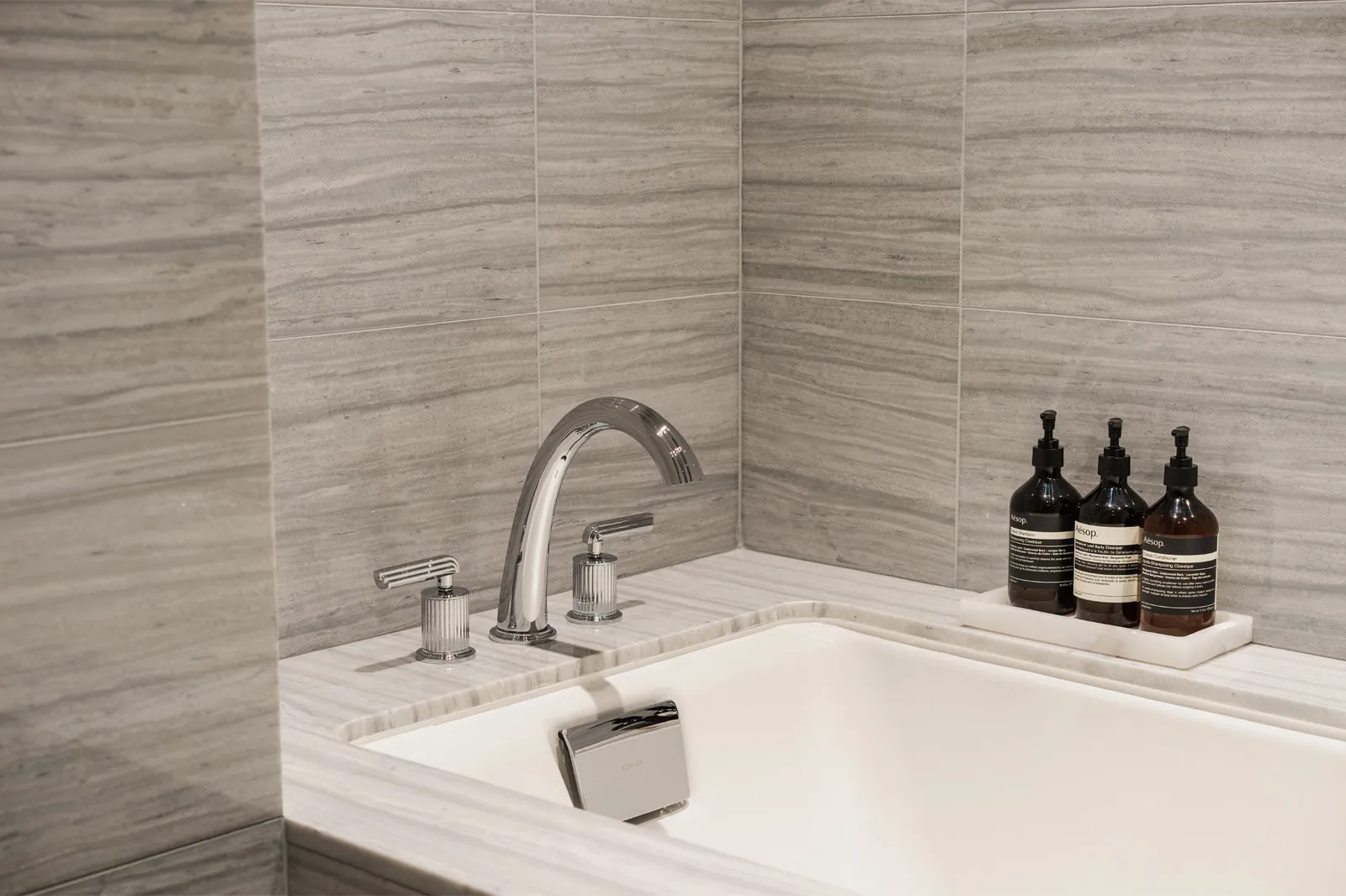 The Deluxe King’s tub between grey marble walls