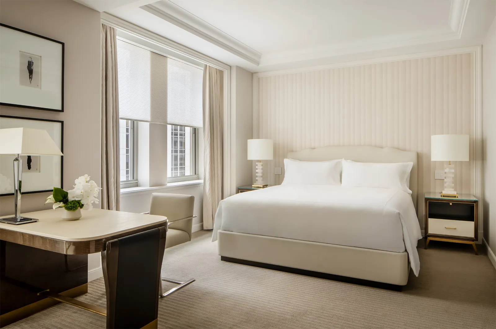 The Junior Suite’s bed between its lamps and the pale wall