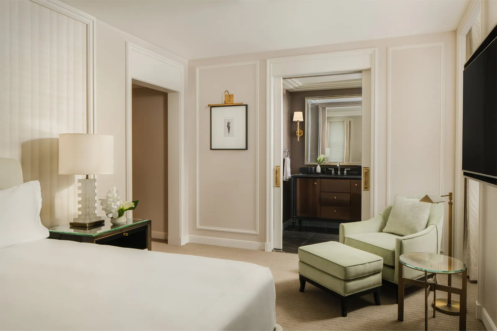 The King Room: the white bed, the green armchair and the door to the marble bathroom