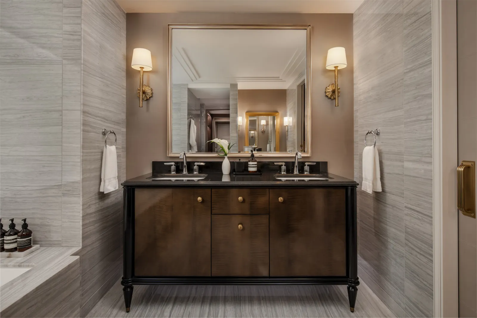 A suite bathroom: double dark-wood vanity and mirror