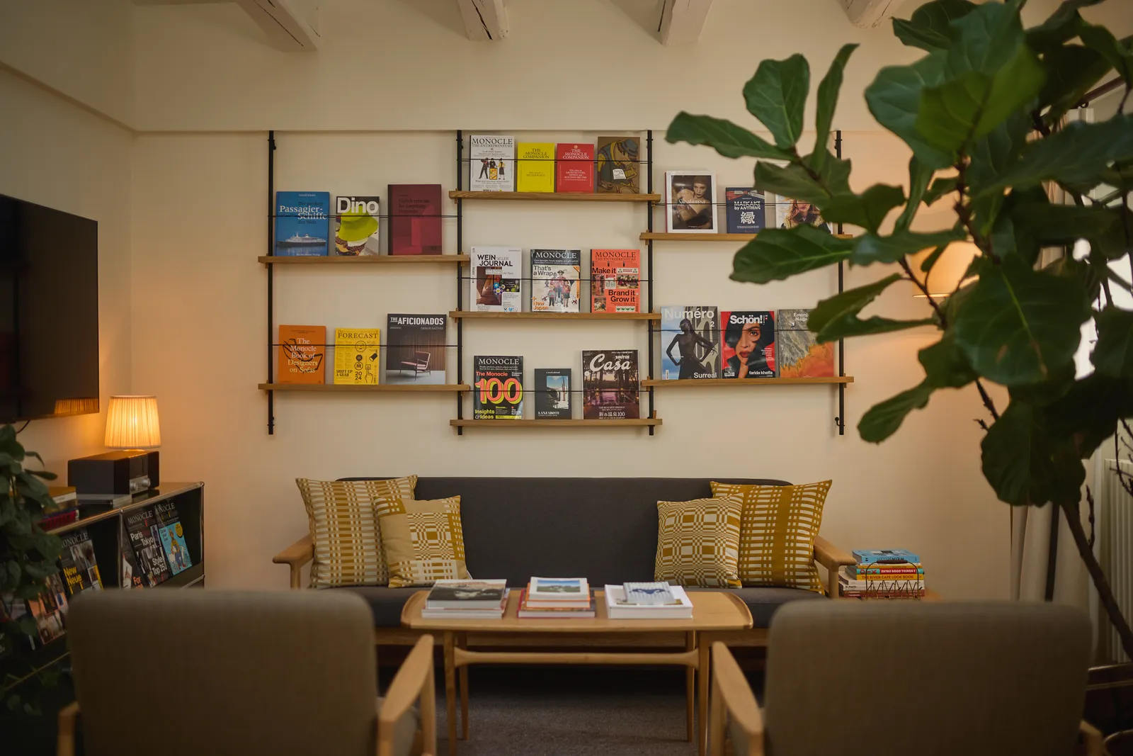 Divano, libreria e riviste nel soggiorno della Monocle Townhouse