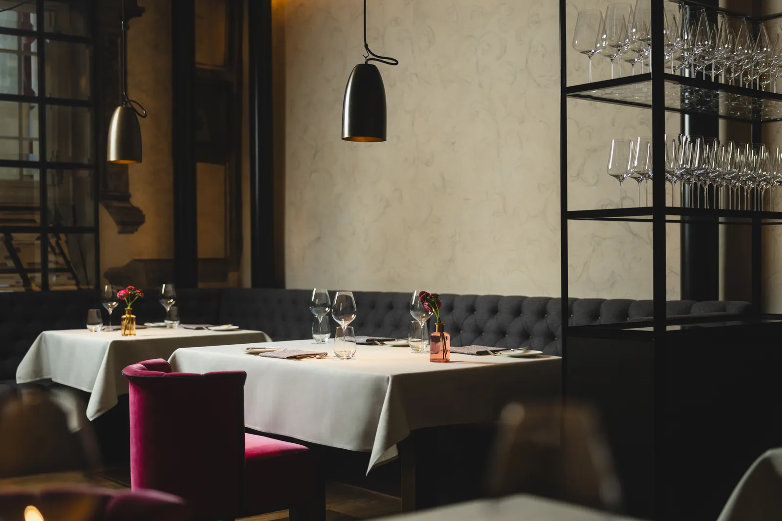 Tavoli apparecchiati, sedie bordeaux e pareti storiche al Widder Restaurant