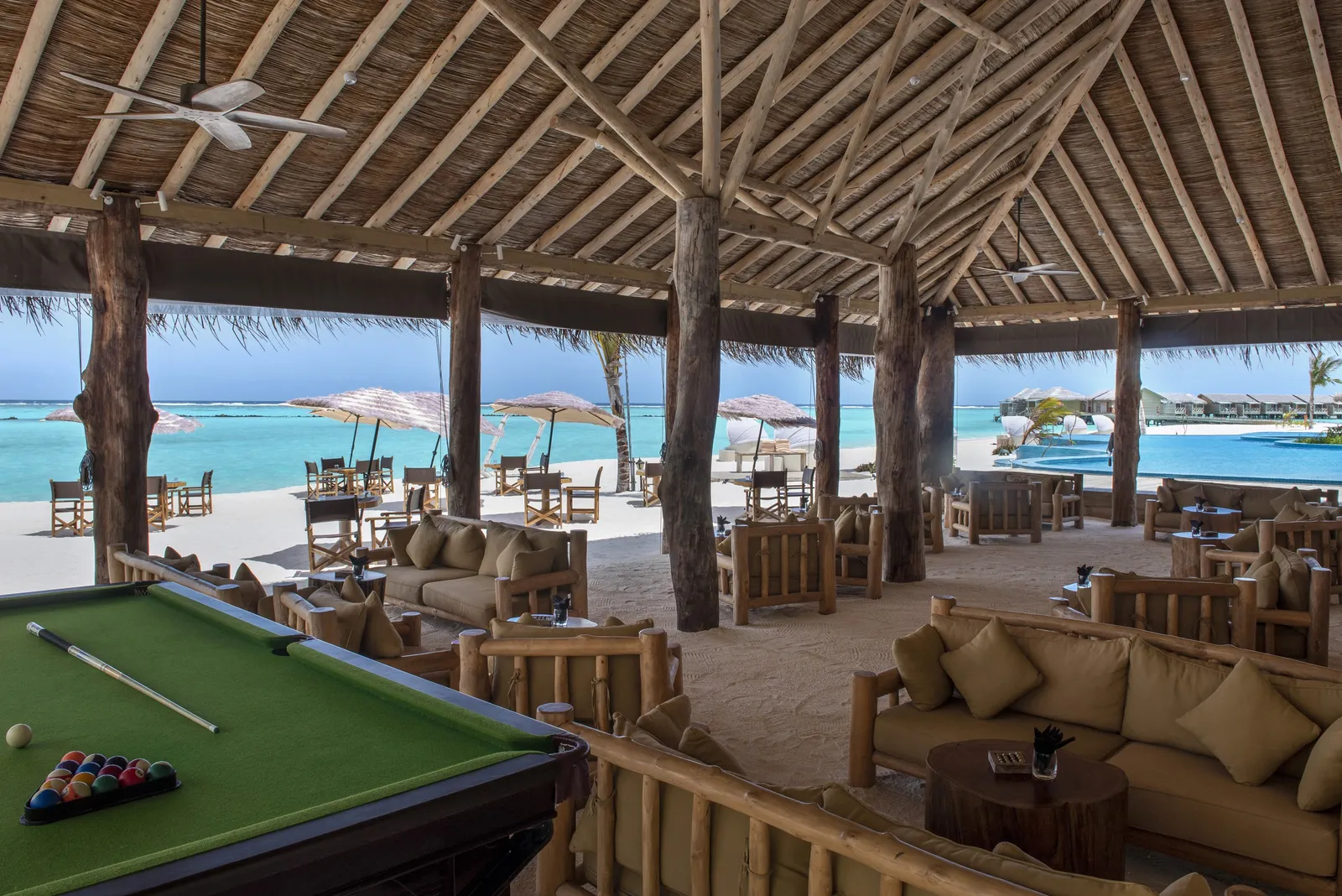 Cheers Bar beneath its thatched roof: the pool table, the sofas and the pool beyond