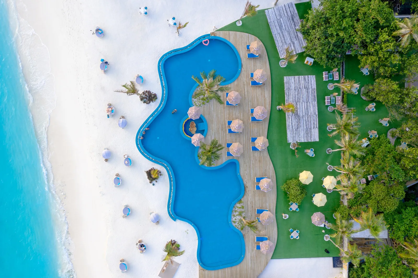 The main pool from above, between the beach and the lawn, loungers around it