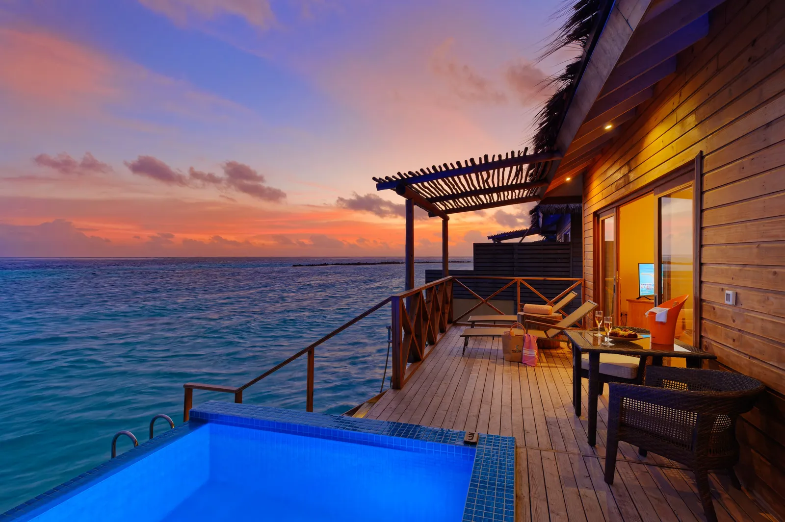 An Aqua Suite with Private Pool’s deck at sunset, the pool lit