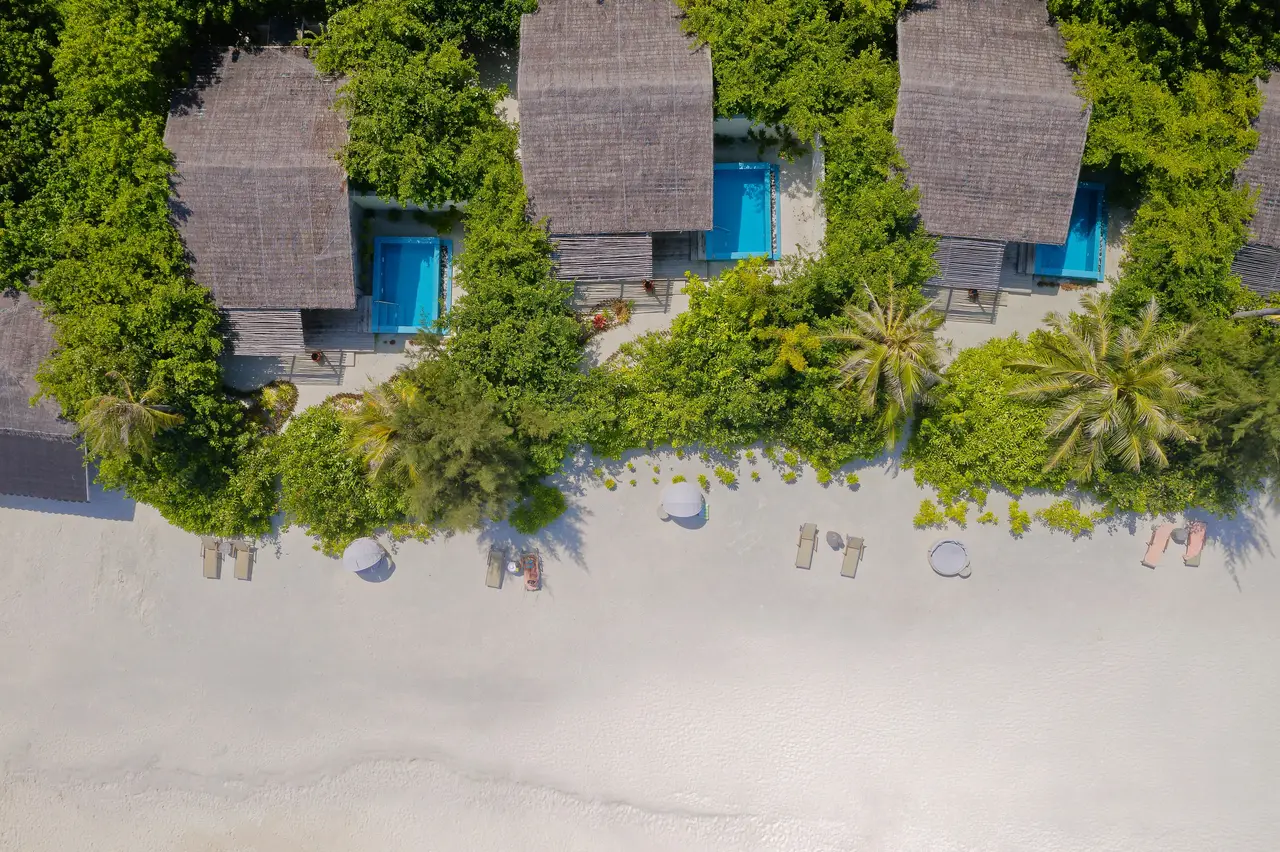 The Beach Suites from above, their pools among the greenery and the beach in front