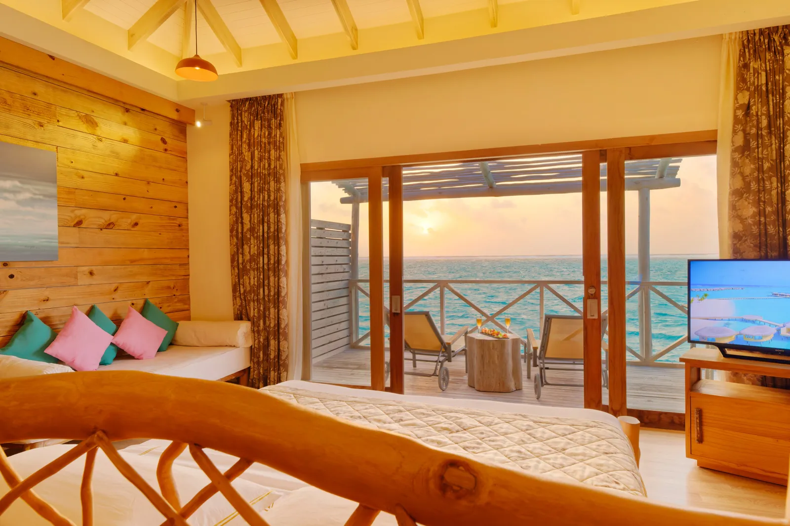 A Lagoon Suite at sunset, the bed facing the deck over the lagoon