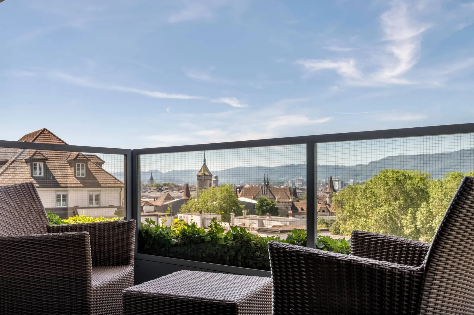 Il balcone della Business Suite, con poltrone e vista sui tetti di Zurigo