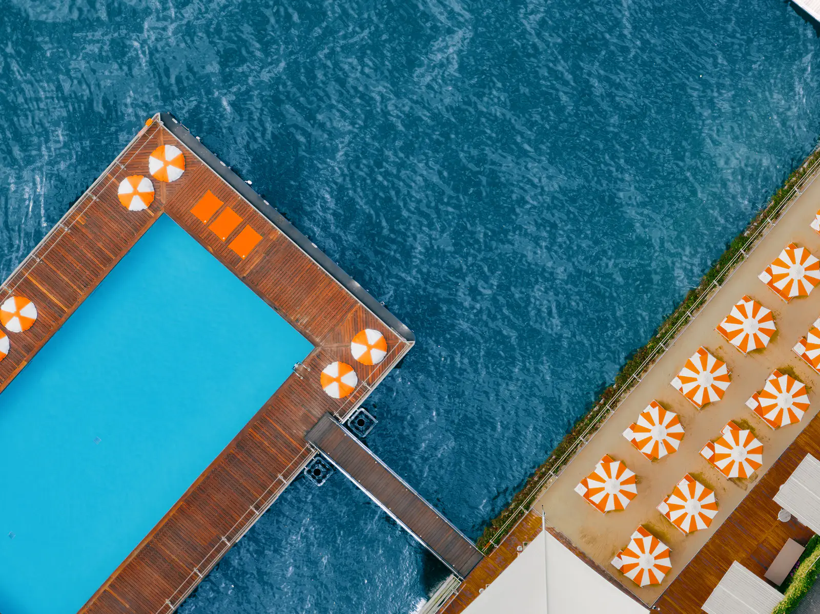 Aerial view of the Water On the Water floating pool and orange parasols