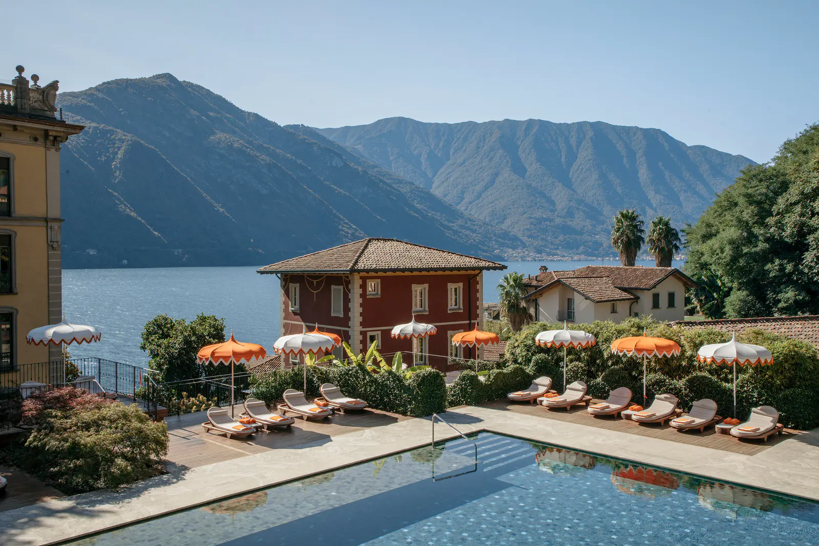 La Piscina dei Fiori nel parco del Grand Hotel Tremezzo, con ombrelloni e la villa rossa