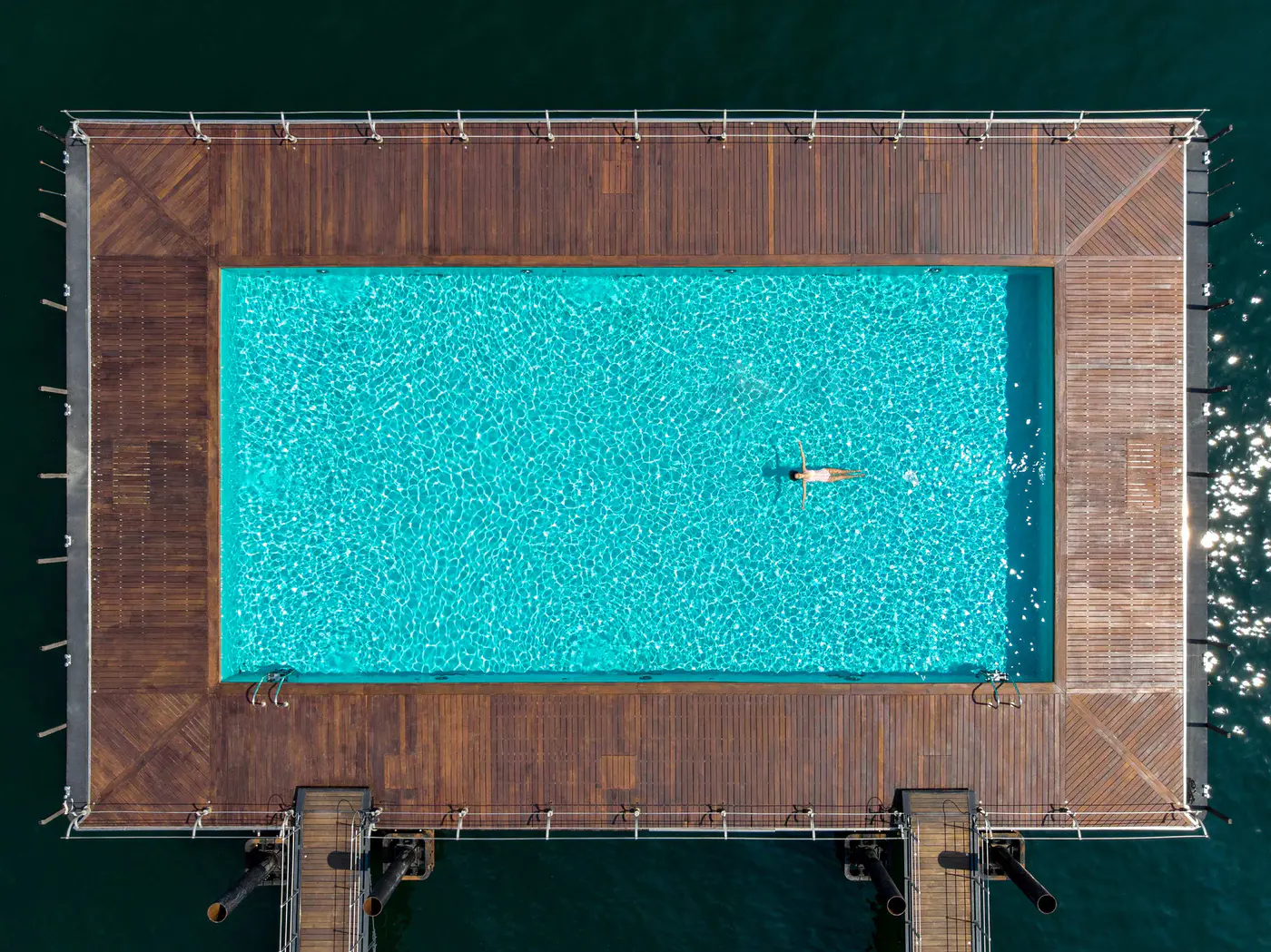 La piscina galleggiante del Grand Hotel Tremezzo fotografata dall’alto, un nuotatore solo nell’acqua