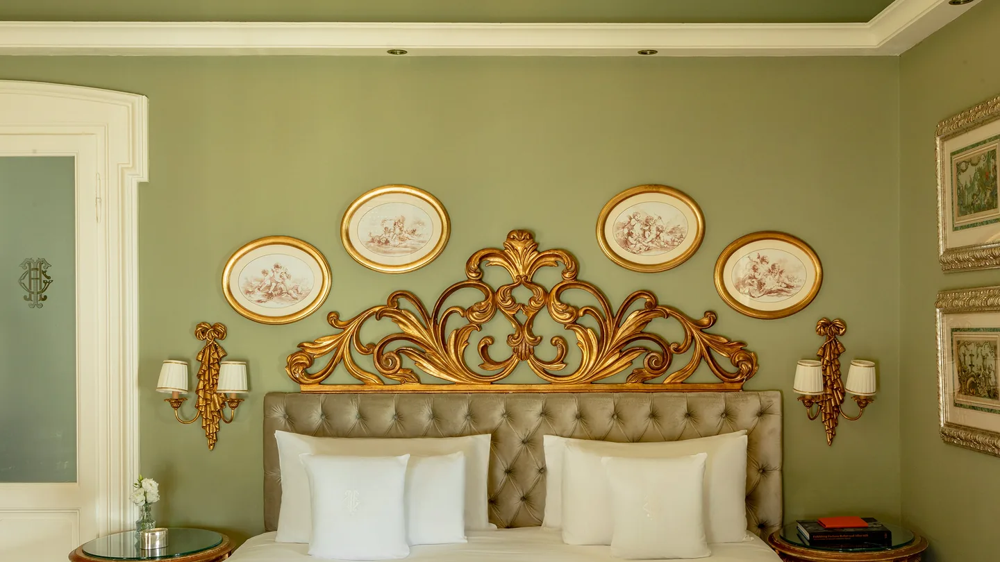 Lake-view Deluxe Room with a gilded headboard and green walls
