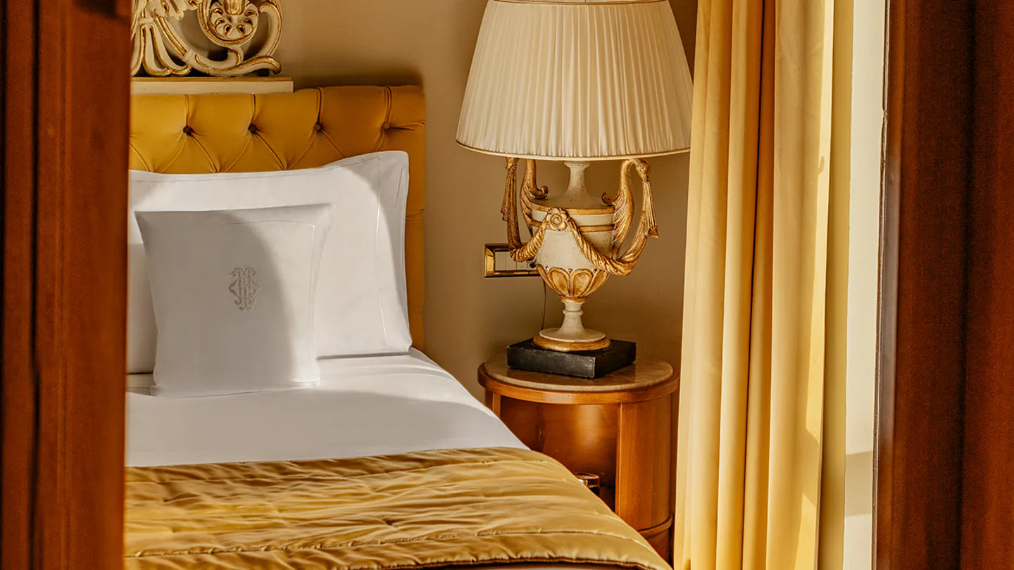 Signature Suite with gilded mirrors and a yellow headboard
