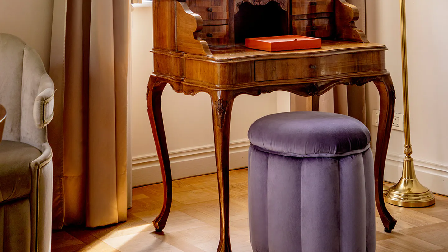 Antique writing desk in Suite Emilia beside a lake-facing window